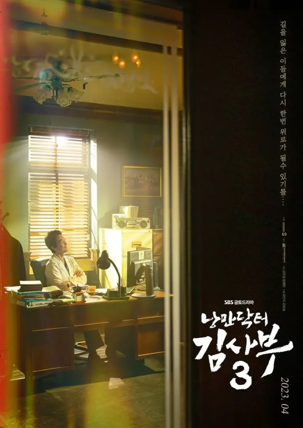 김사부가 책상에 앞에 앉아 있는 팔짱을 낀채 미소짓고 있는 포스터