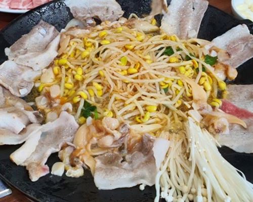 불판에-올려진-삼겹살과-조개