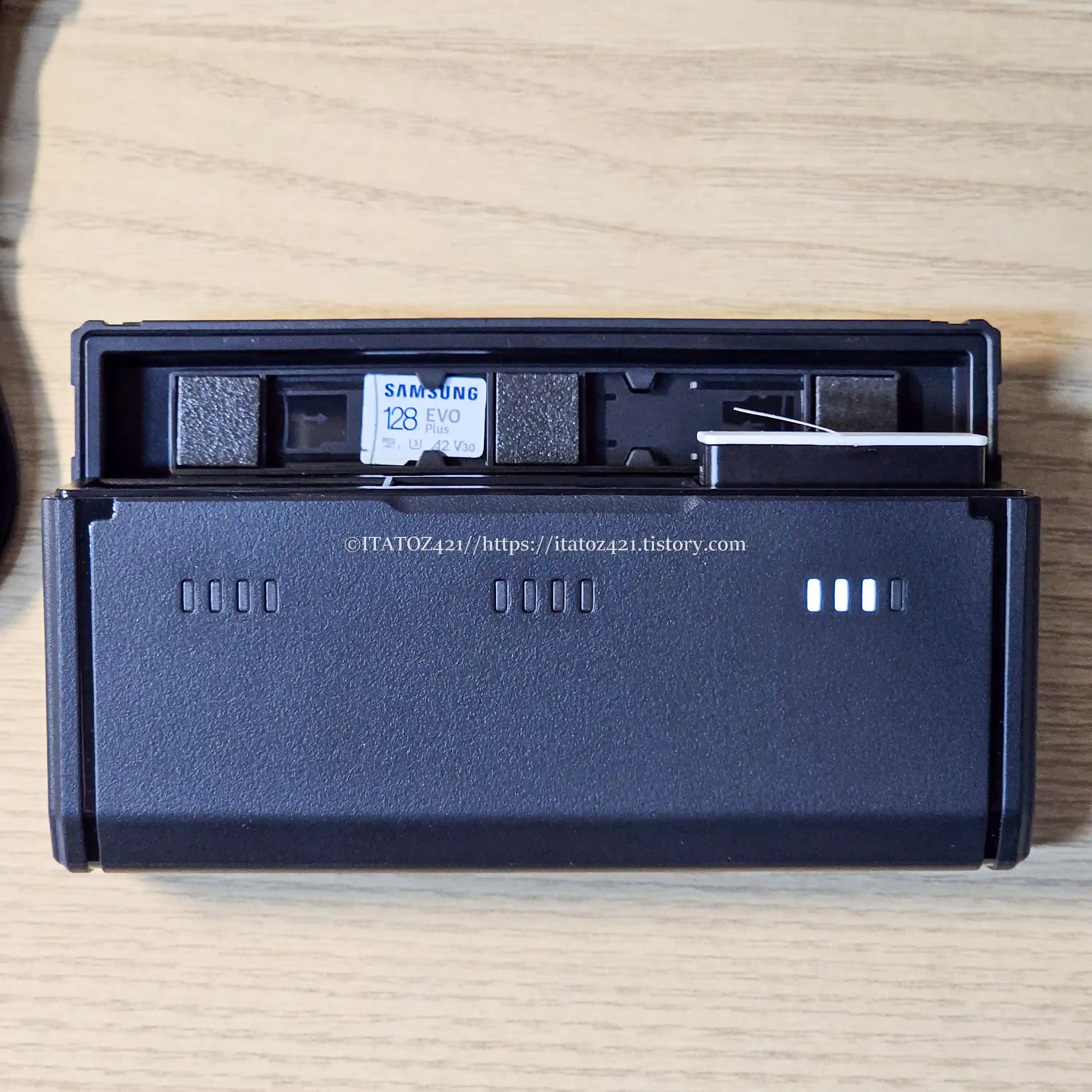 텔레신 고프로 멀티 충전기 케이스는 뚜껑 상단 SD카드 보관 슬롯 2개 배터리 충전 슬로 3개가 있으며 뚜꼉을 열었을 때 전면에 있는 LED 인디케이터로 잔량을 확인할 수 있다.