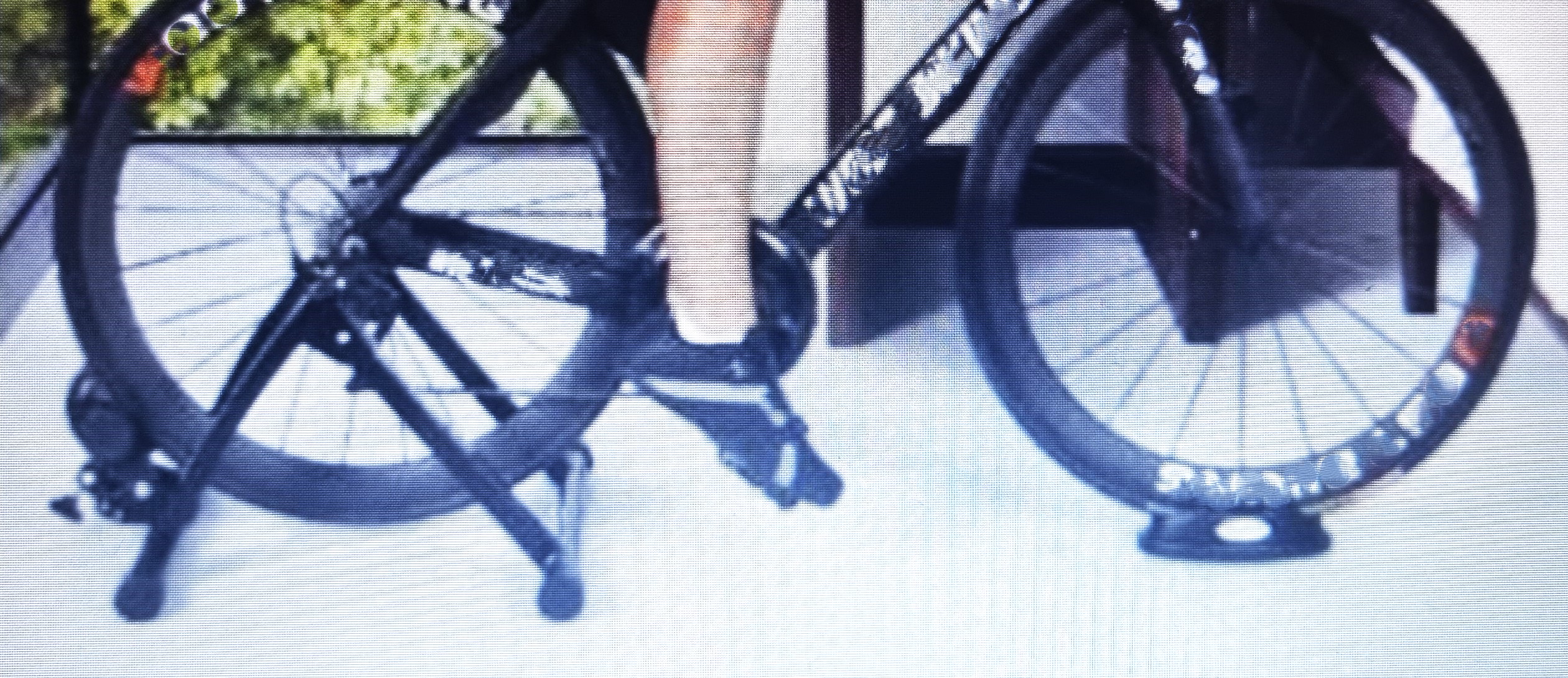 실외 자전거 뒷바퀴에 장착된 삼각롤러&#44; 검은색&#44; 가운데 페달 밟고 달리고 있는 자전거 승차자의 다리&#44;