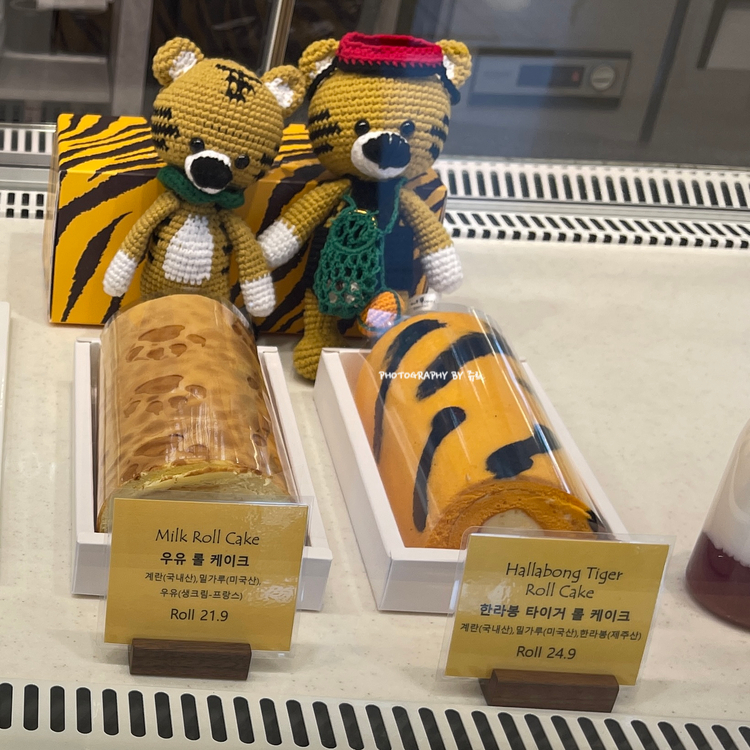 제주호랭이 시그니처 호랑이무늬를 형상화한 한라봉 타이거 롤케이크오 우유 롤케크가 쇼케이스에 진열되어 있는 사진