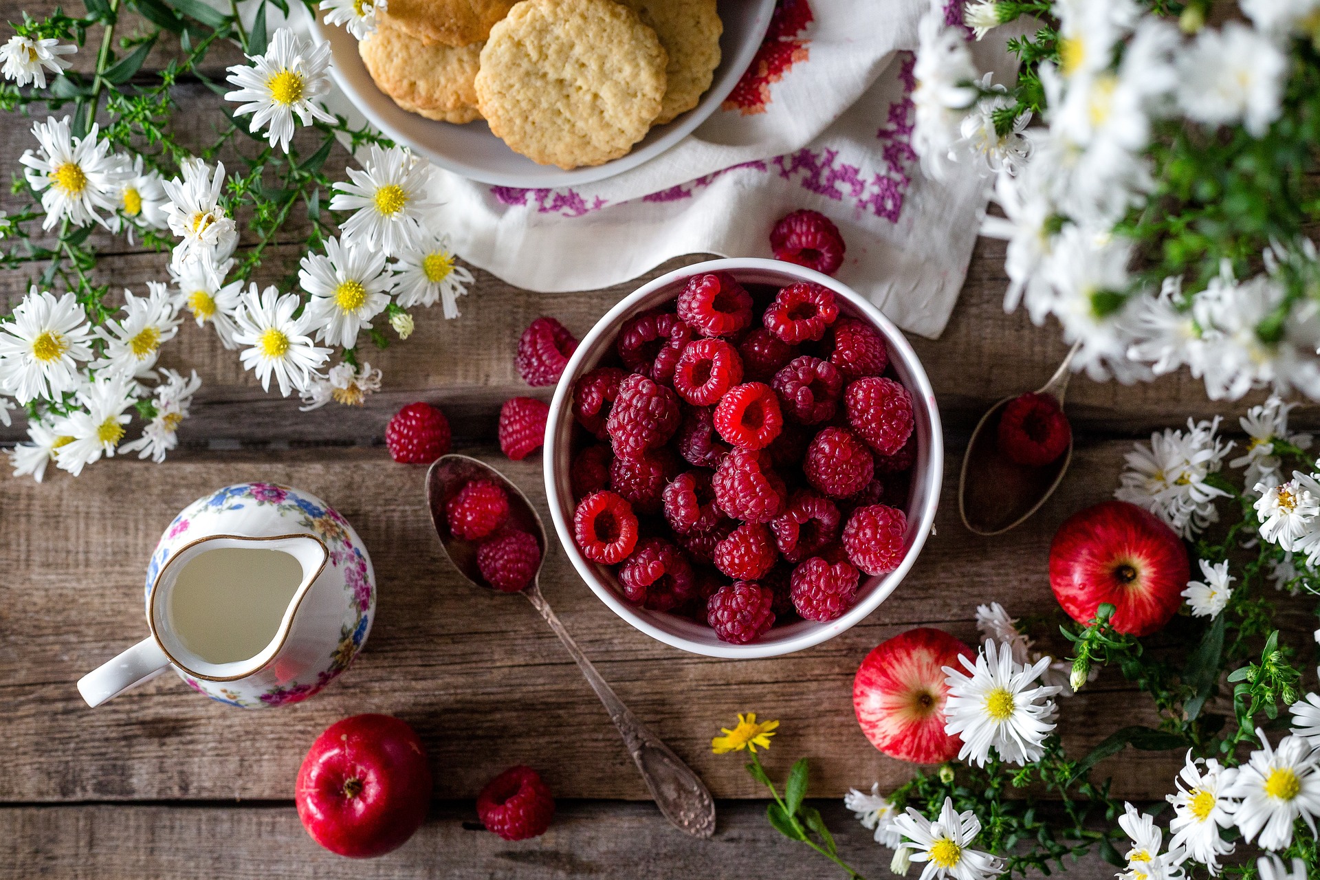 하얀 그릇에 산딸기를 가득 담고&#44; 그 주위에 빵과 사과와 꿀을 담은 단지&#44; 그리고 꽃으로 장식을 한 사진 - 소양인(少陽人)에게 맞는 음식
