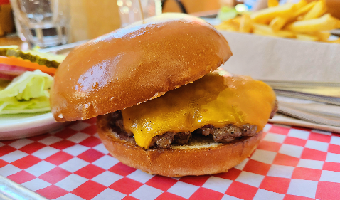 Cassell&amp;#39;s Hamburgers의 Classic Cheese Burger의 옆면. 두꺼운 체다치즈가 패티를 덮고 있다.