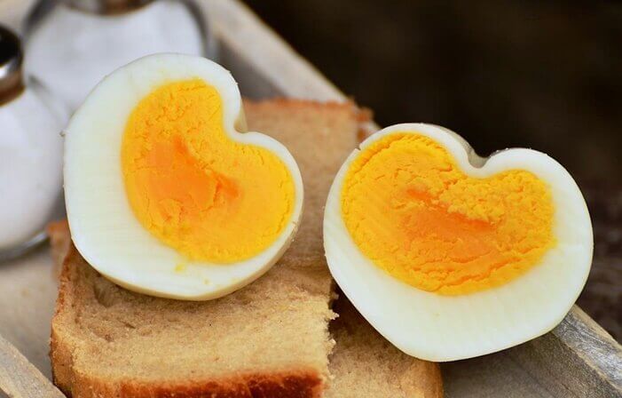반으로 잘려진 삶은 계란이 식빵 위에 올려져 있는 모습