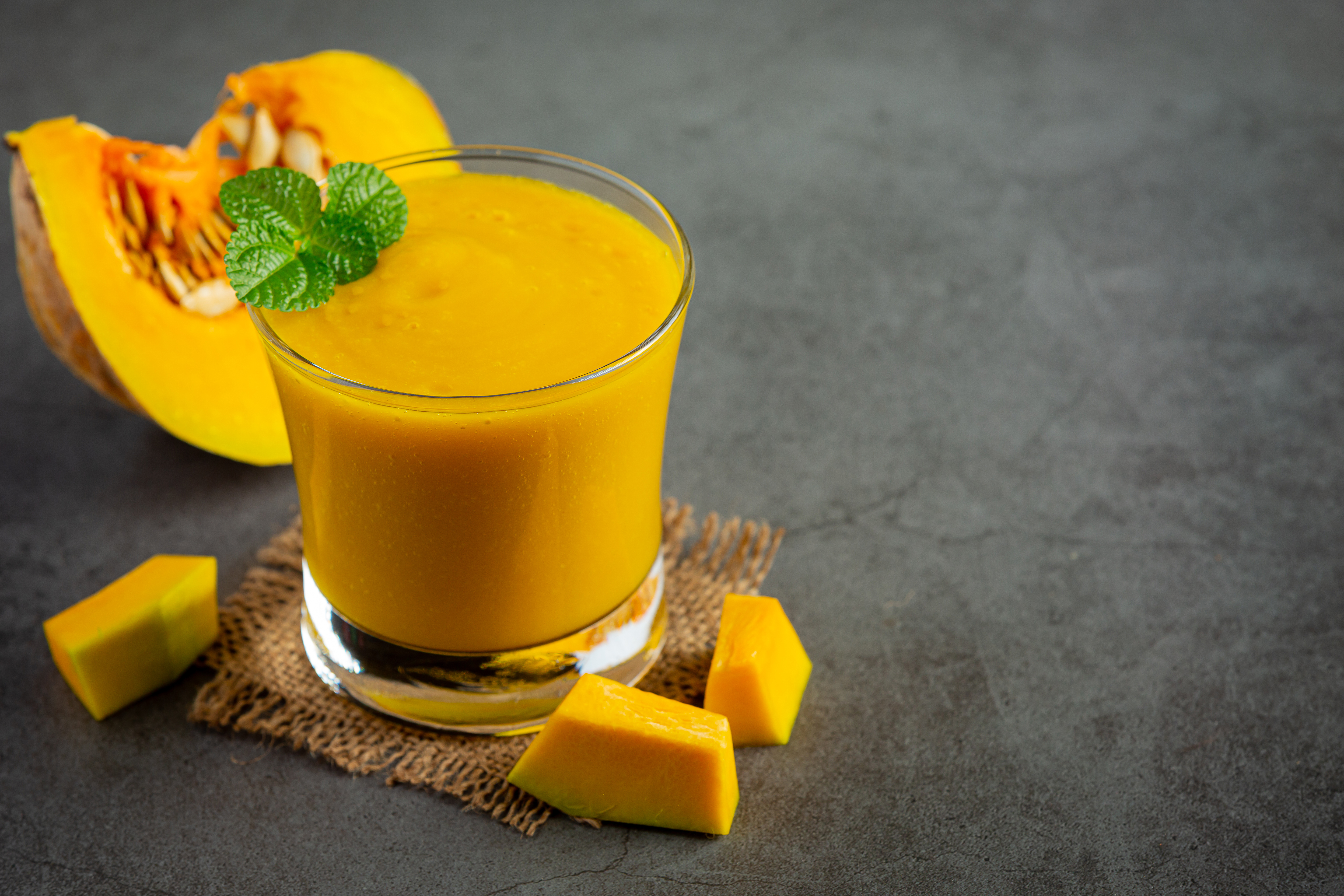 glass-pumpkin-juice-chopped-raw-pumpkins-place-dark-floor