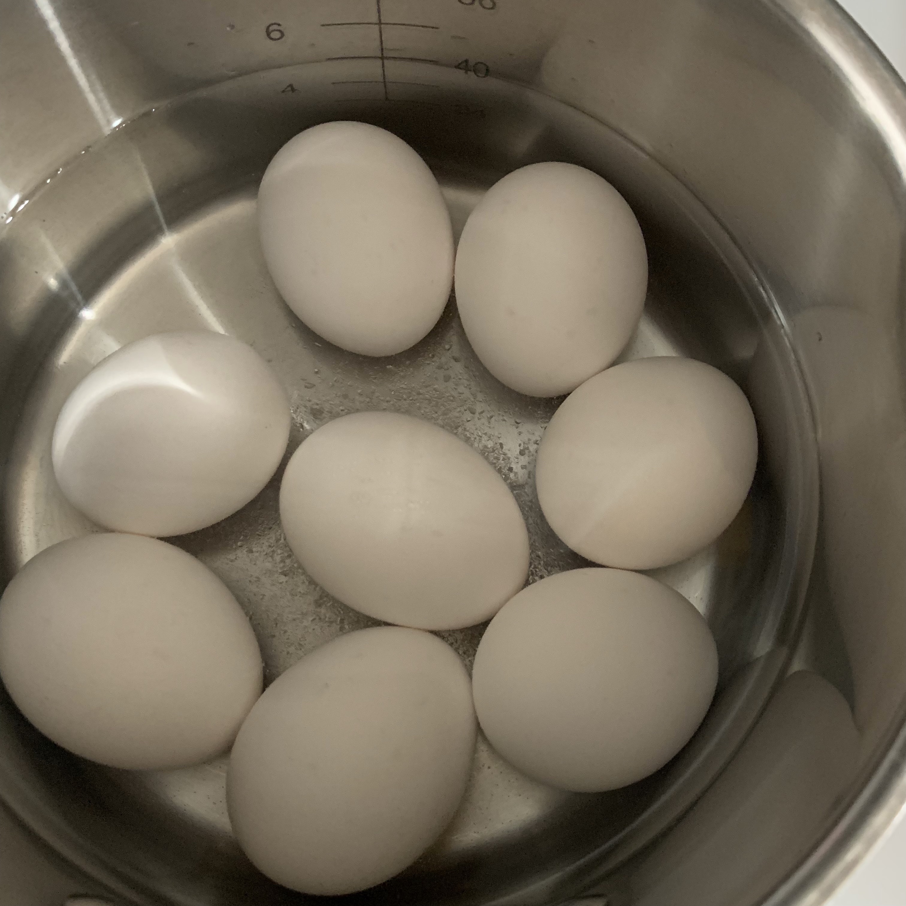은색냄비-흰색달걀-8알이-물에-반쯤-잠긴-모습