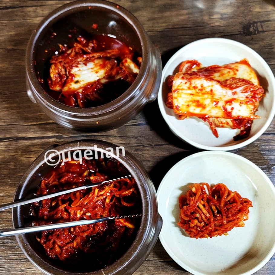  밀밭 칼국수 양주 본점 반찬 김치와 무채가 항아리에서 앞접시에 덜어놓은 사진이다.
