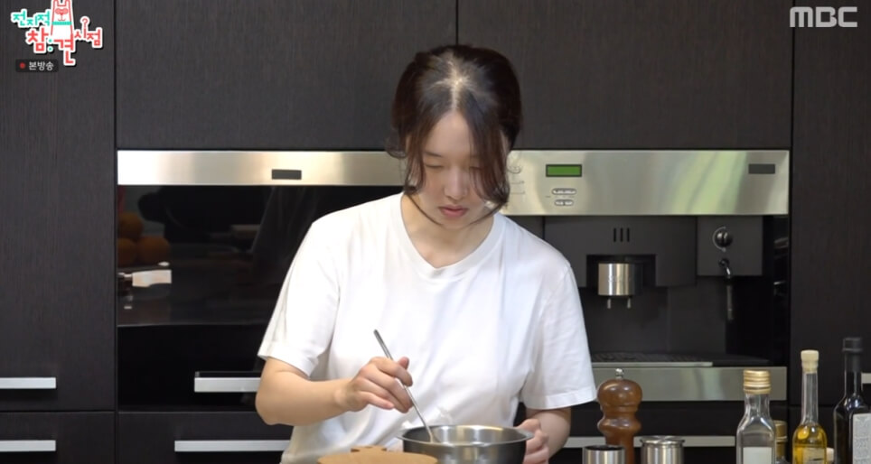 주방에음식을하고있는-머리묶은여성의모습