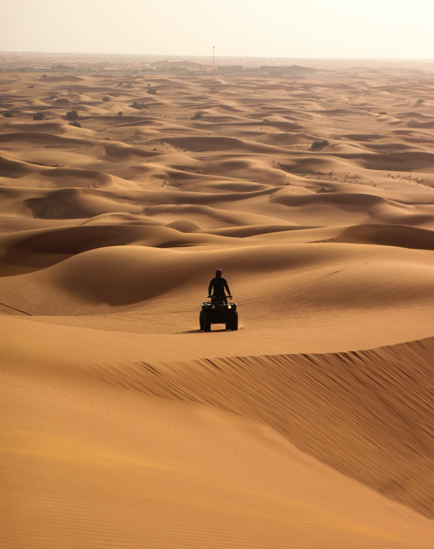 사막에서 쿼드 바이크를 타고 있는 한 사람