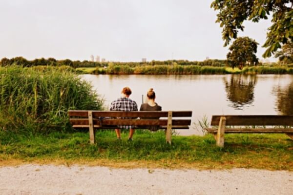 호숫가 벤치에 조용히 앉아있는 남녀의 뒷모습