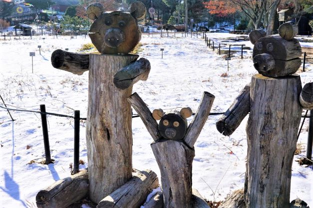 눈밭에 세워 놓은 통나무로 만든 곰 세마리&#44; 아빠 곰&#44; 엄마 곰&#44; 아기 곰&#44;