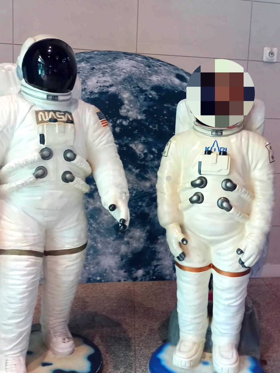 지구-모형-앞에-흰색-옷을-입은-우주인-모형을-찍은-사진