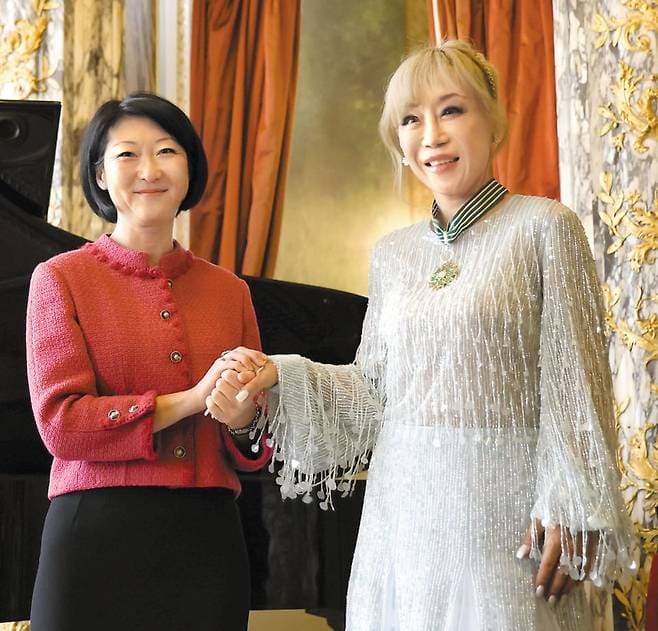 Soprano Cho Soo-mi holds hands with former French Culture Minister Fleur Pellerin&#44; who is of Korean descent&#44; after she was awarded the Commander of the Order of Arts and Letters&#44; France&#39;s highest honor for cultural achievement&#44; at the Opéra Comique theater in Paris&#44; France&#44; on Saturday.
