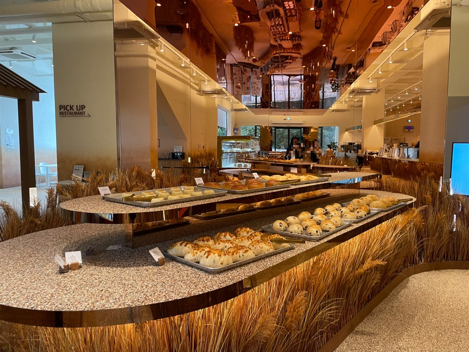 디오름 카페의 1층 메인공간으로 빵들과 갈대들이 바닥에 있다.