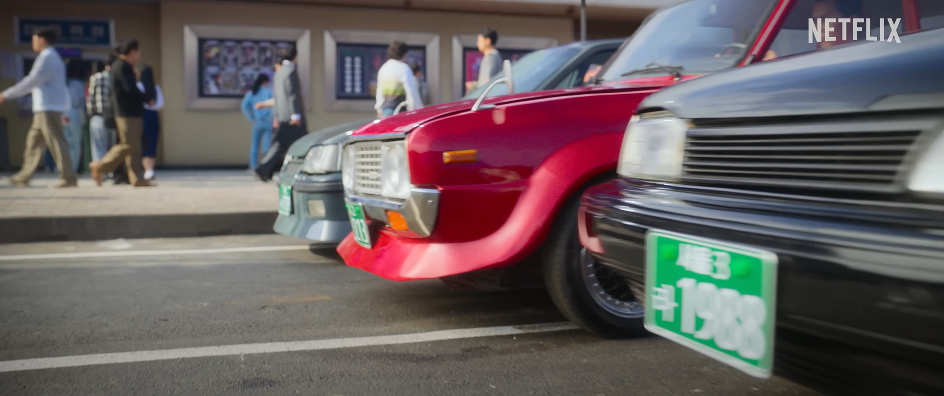 넷플릭스 영화 서울대작전의 한 장면&#44; 경주용 자동차 3대가 대기를 하고 있다.