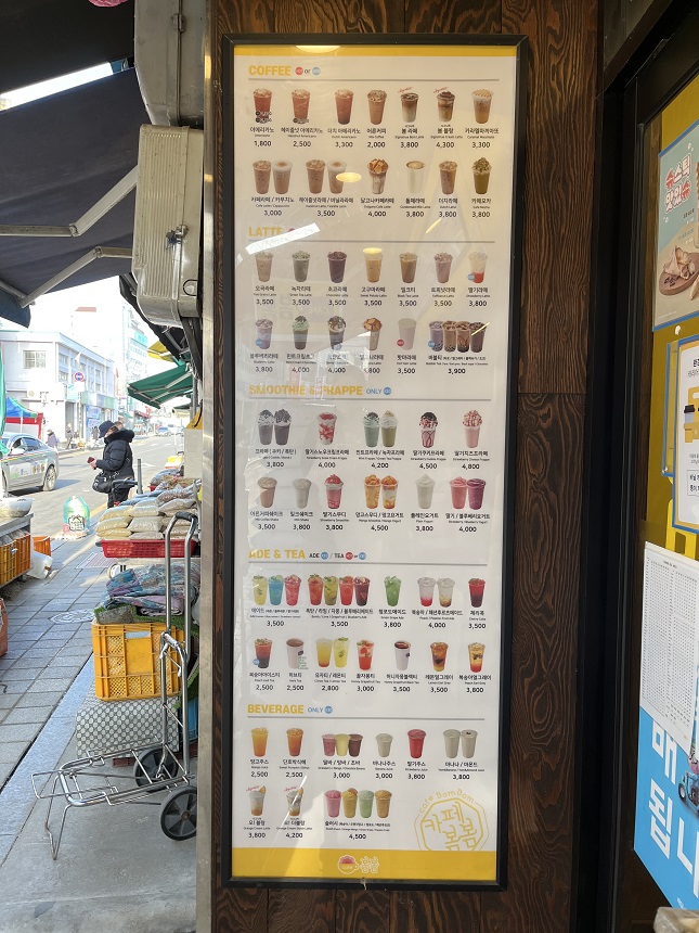 벽에 사진과 가격이 있는 긴 직사각형 메뉴.