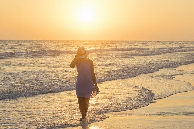 한 여인이 바닷가를 걷고 있는 모습