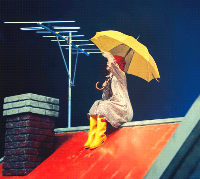 레인코트 입고 우산 쓰고 지붕에 앉아있는 소녀