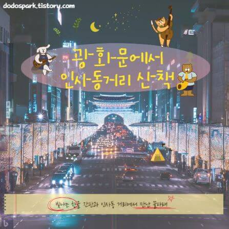 고층빌딩사이에 경복궁 불빛이 비치고 있고 반짝이는 가로수가 가득한 광화문 밤 거리