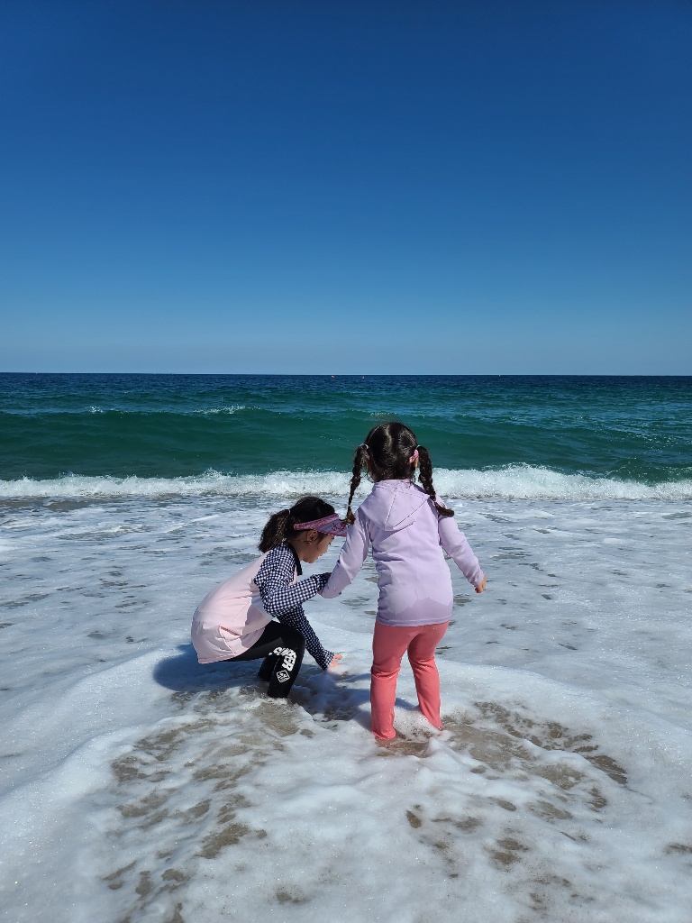 두 아이들이 켄싱턴해변에서 파도에 즐거워 하는 뒷모습