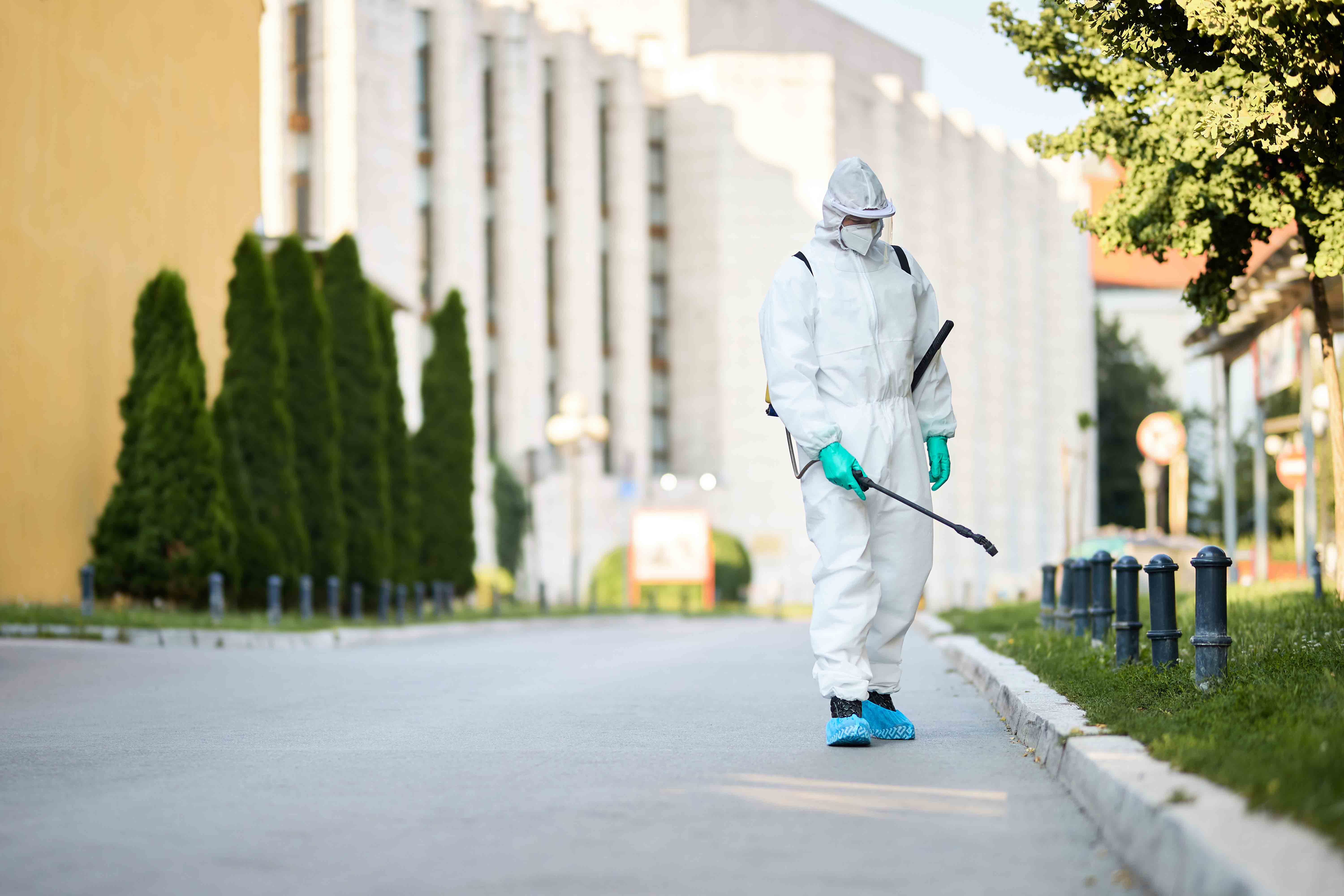 man-protective-suit-disinfecting-city-streets
