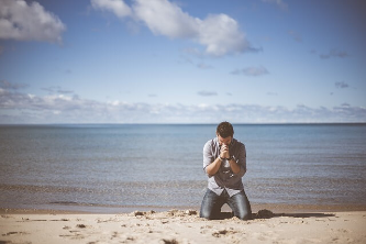 바닷가에서 기도하는 남자 