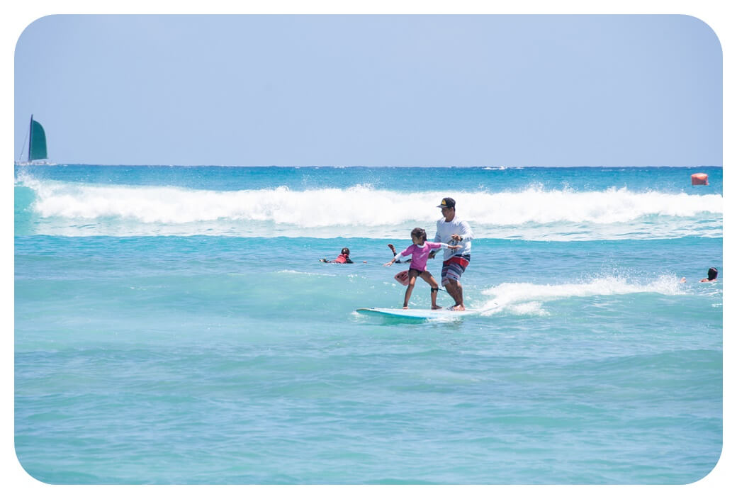 와이키키 해변에서 서핑을 즐기는 관강객들의 모습을 찍은 사진