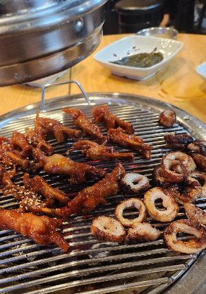 숯불에-매콤한닭발과-막창을-굽고있다