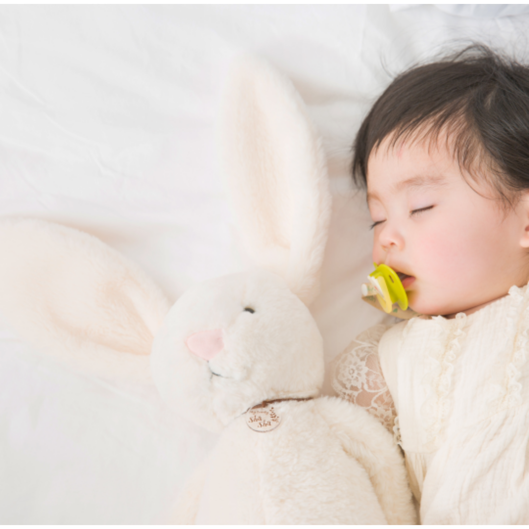 토끼 인형과 젖병을 물고 잠이 든 아기