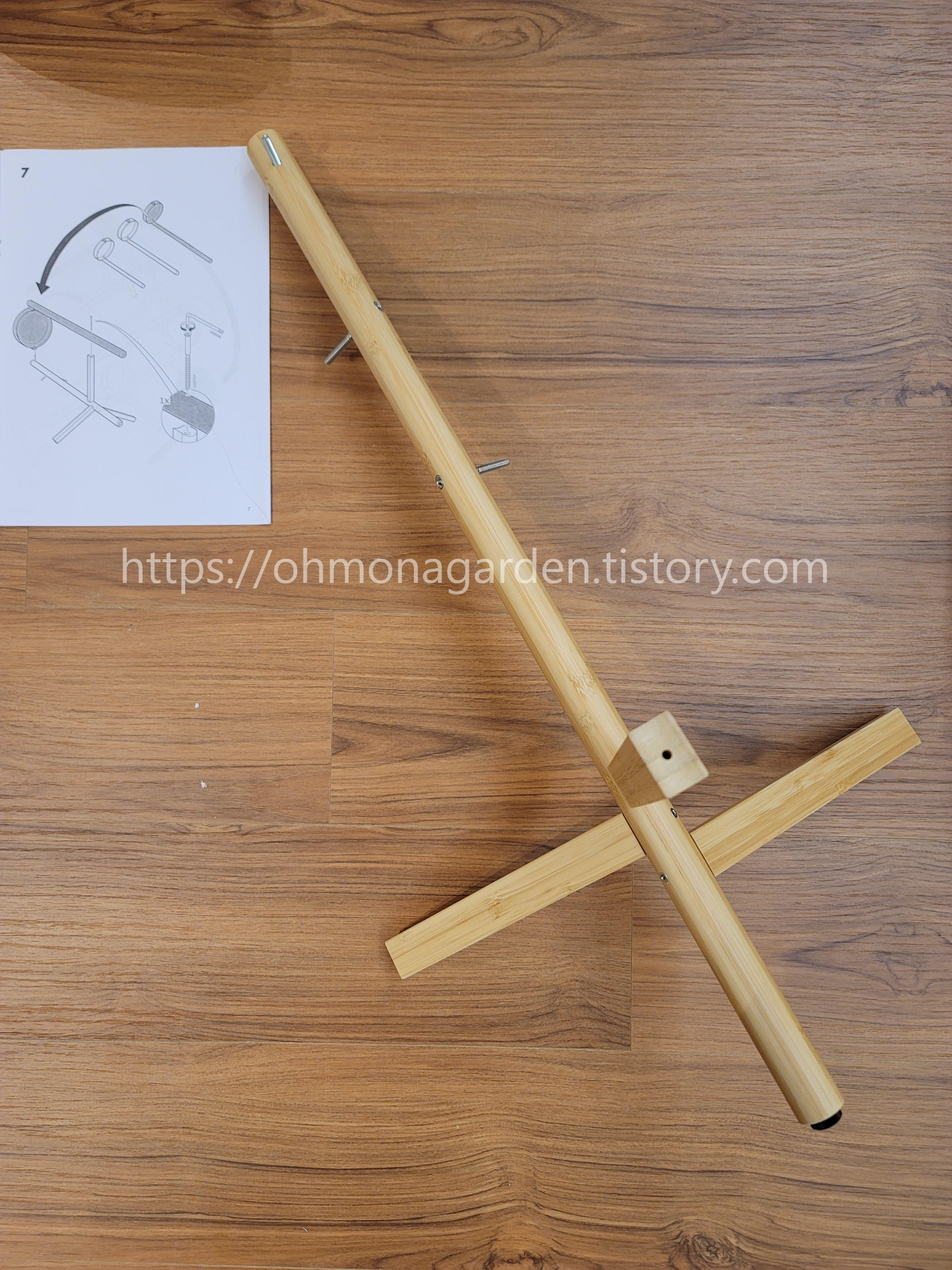 Attach the central pole of the IKEA SATSUMAS to the three legs with attached trays using screws.