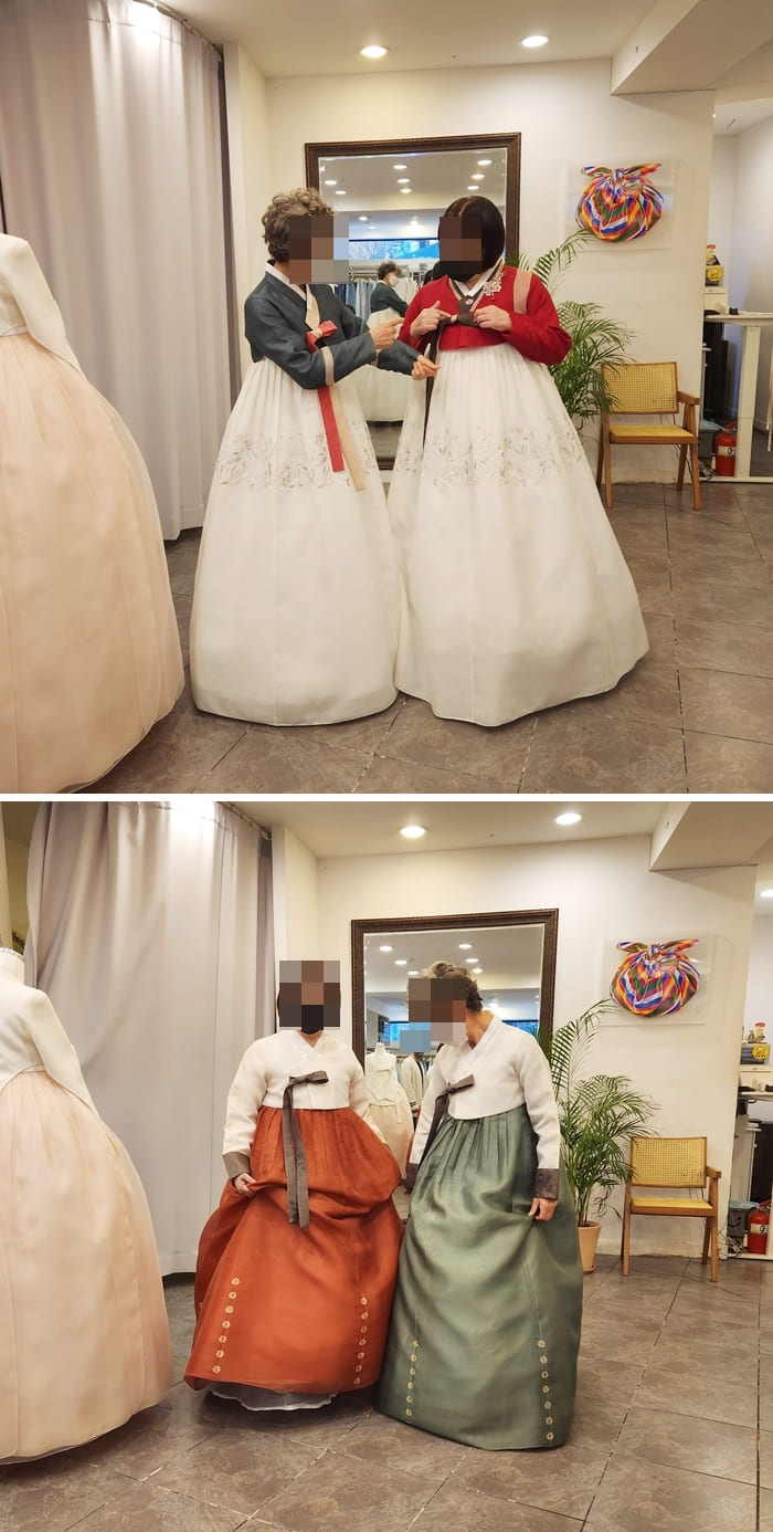 두 가족 모두 한복을 입고 사진을 찍습니다.