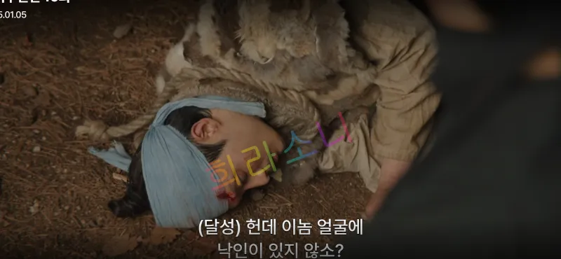돌석이 바닥에 쓰러져 머리에 붕대를 감고 피를 흘리고 있습니다. 그는 의식을 잃은 듯하며&amp;#44; 주변은 어두운 분위기입니다. 자막은 &amp;quot;(달성) 헌데 이놈 얼굴에 낙인이 있지 않소?&amp;quot;