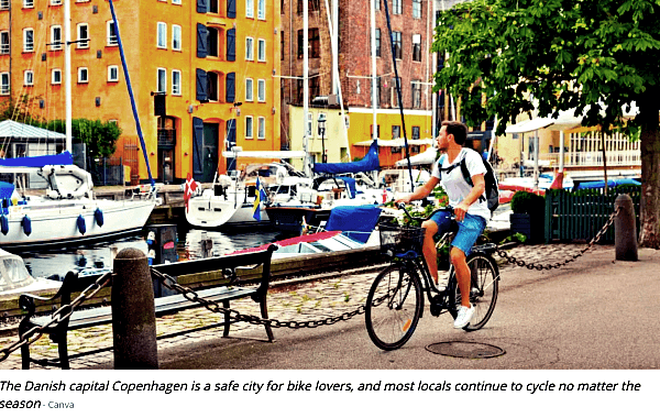 요트가정박해있는-모습을보는-반바지를-입은-한남자가-자전거를-타고있는-덴마크-코펜하겐