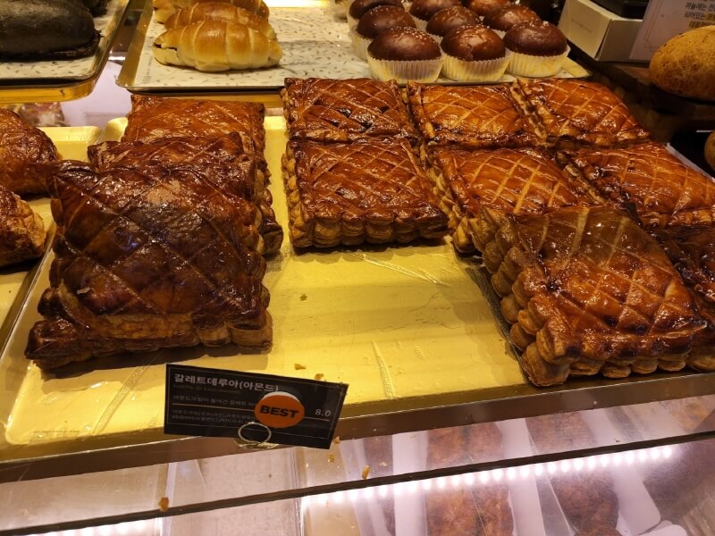 갈레트 데 루아. 손바닥 보다 큰 네모난 파이고 중간중간에는 실로 묶었던 자국이 있는 갈색 파이가 진열되어 있다.