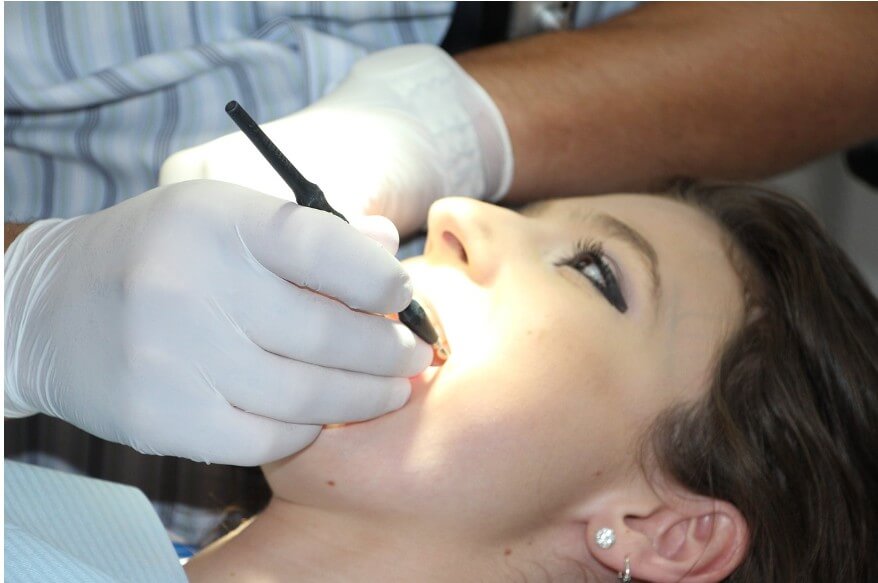 dental plaque를 제거하는 치료를 받고 있는 여성의 모습