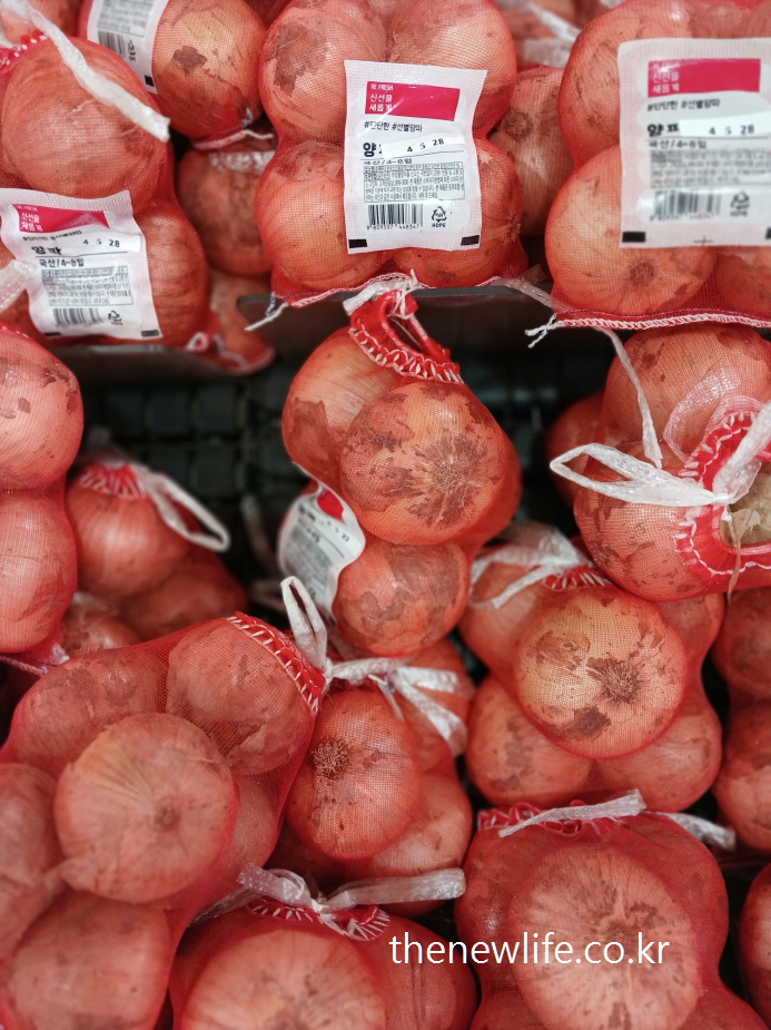 Korean onions packed in red net bags at a grocery store&quot;-마트에서 빨간 망에 담긴 한국산 양파