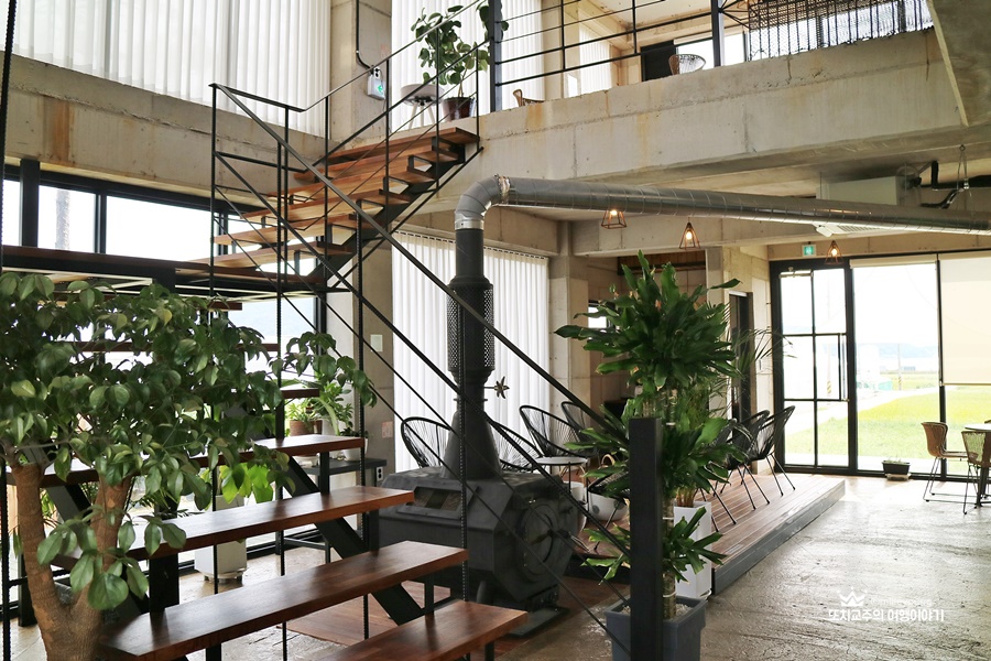 2층으로 이어진 계단이 있고 2층에는 난로와 식물이 있다