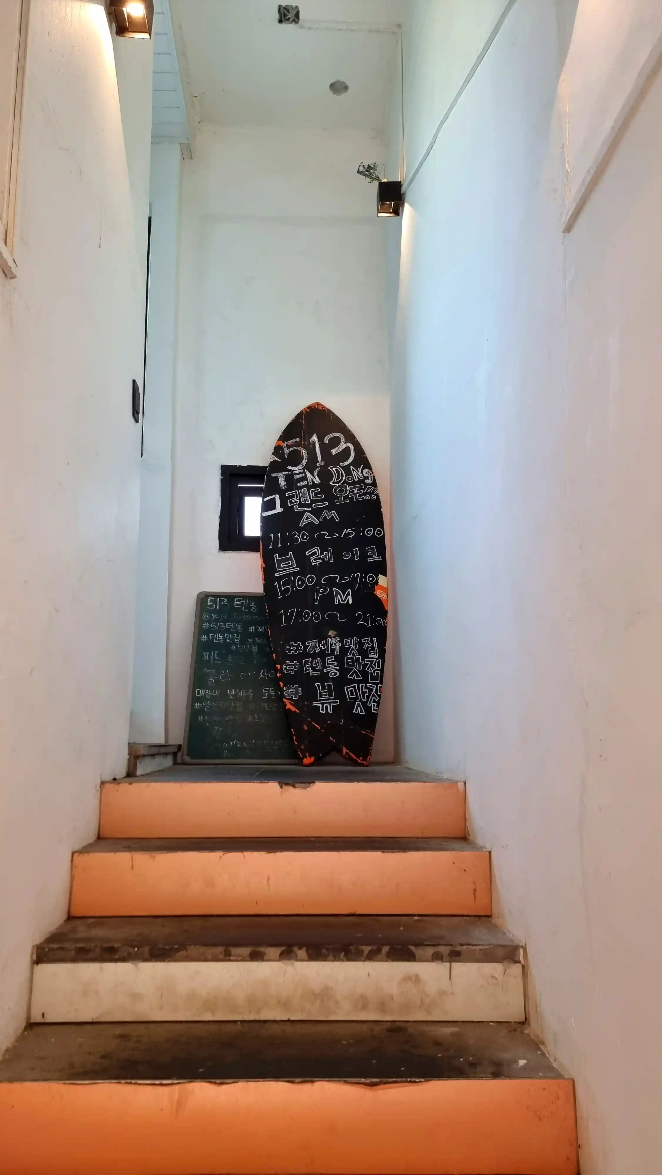 2층 올라가는 계단 끝에 있는 서핑 보드 안내판