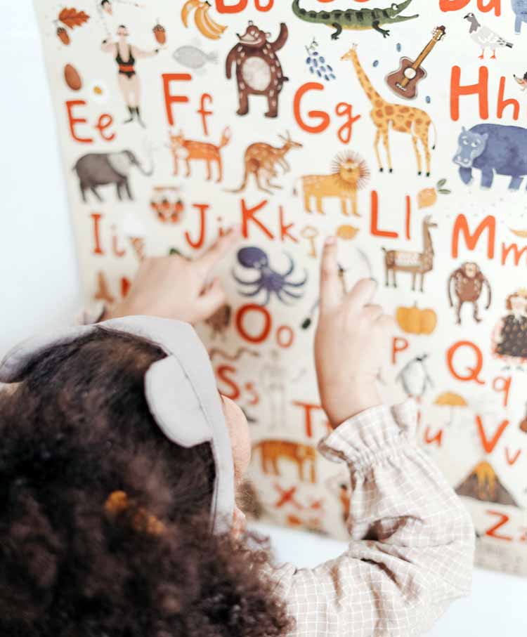 영어알파벳이-있는-포스터를-손가락으로-가리키는-어린아이