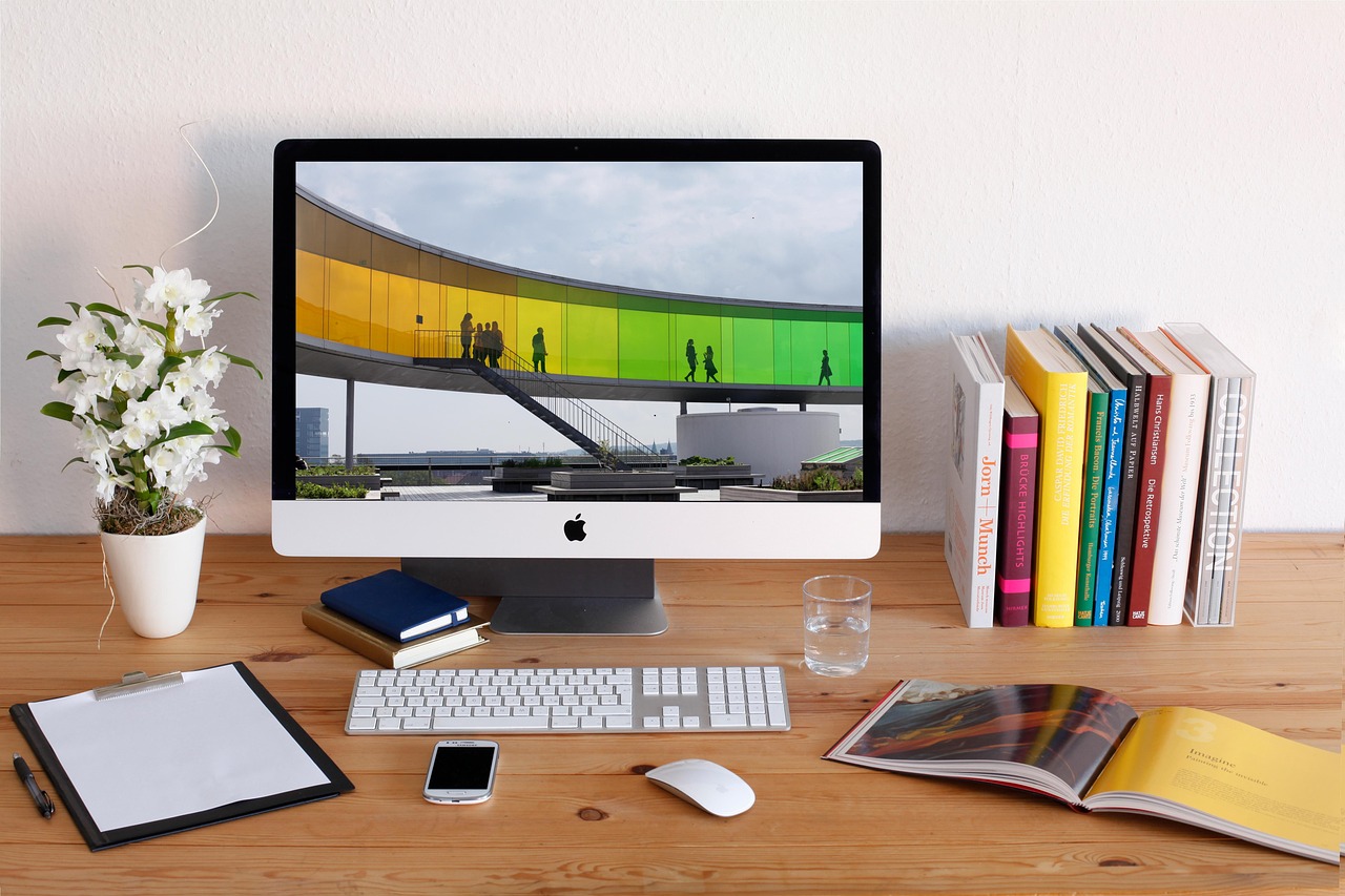 Home office setup with computer, books, and notepad, symbolizing a smart and organized start to online business for people in their 50s