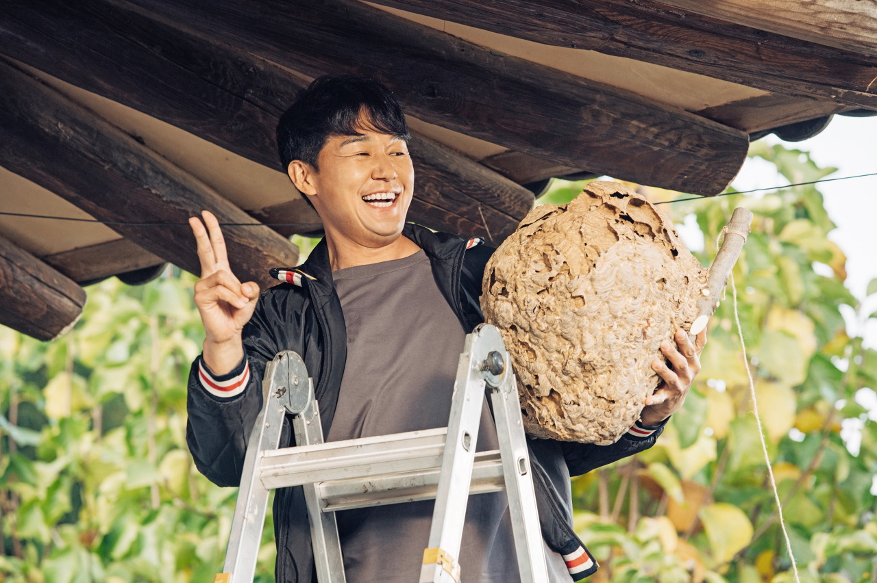 영화 &#39;웅남이&#39;에서 웅남이 역할을 맡은 박성웅이 벌집을 들고 해맑게 웃고 있는 모습이다.