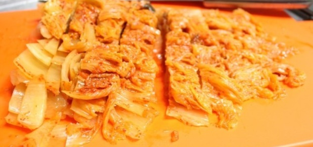 김치를 도마에서 자르고 있다