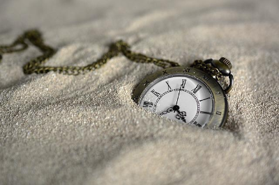 모래속에 반쯤 파 묻혀 있는 시계