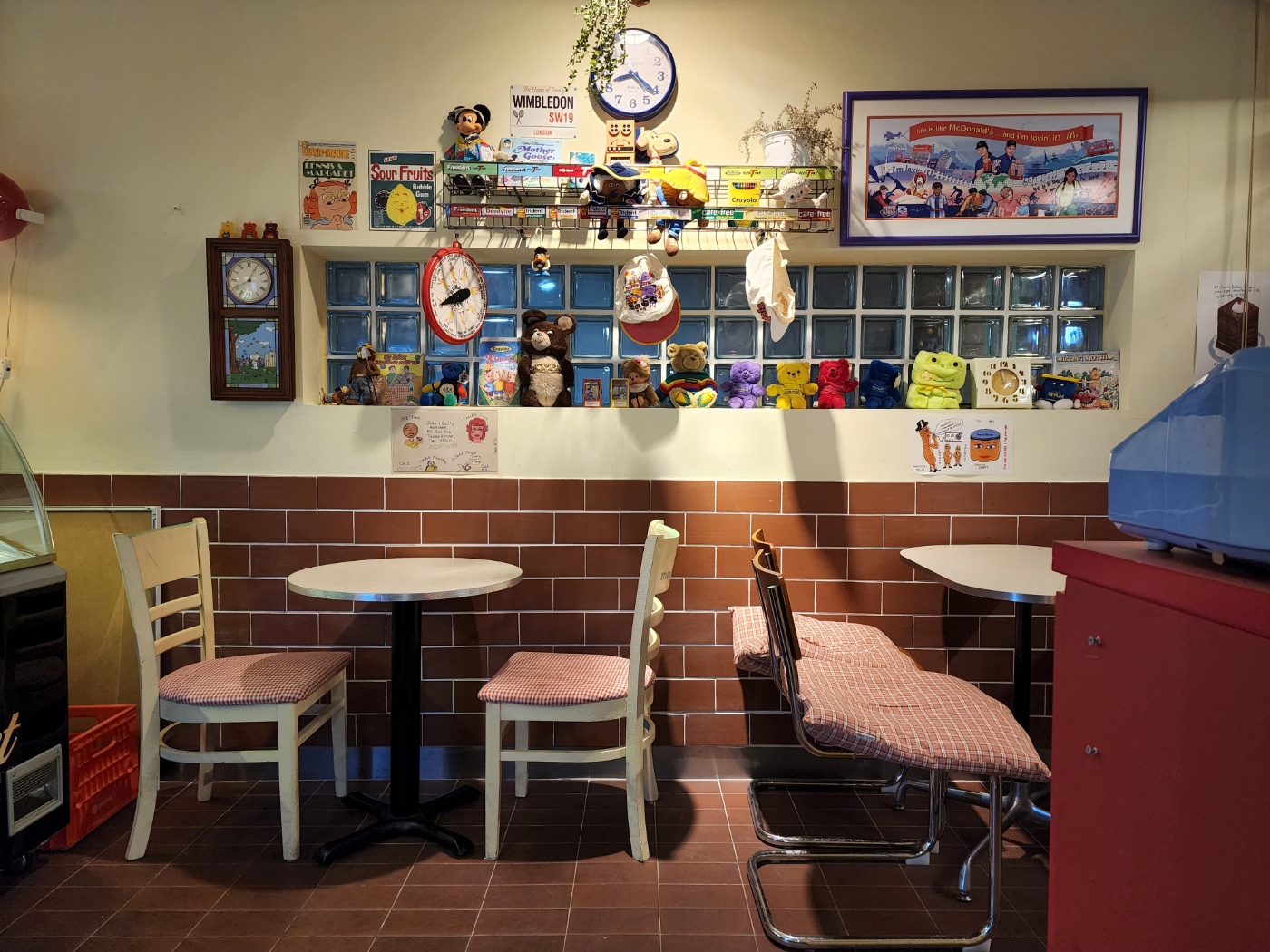 카페 내부의 아쿠아창문과 벽면에 다양한 장식품으로 꾸며진 테이블 자리 전경