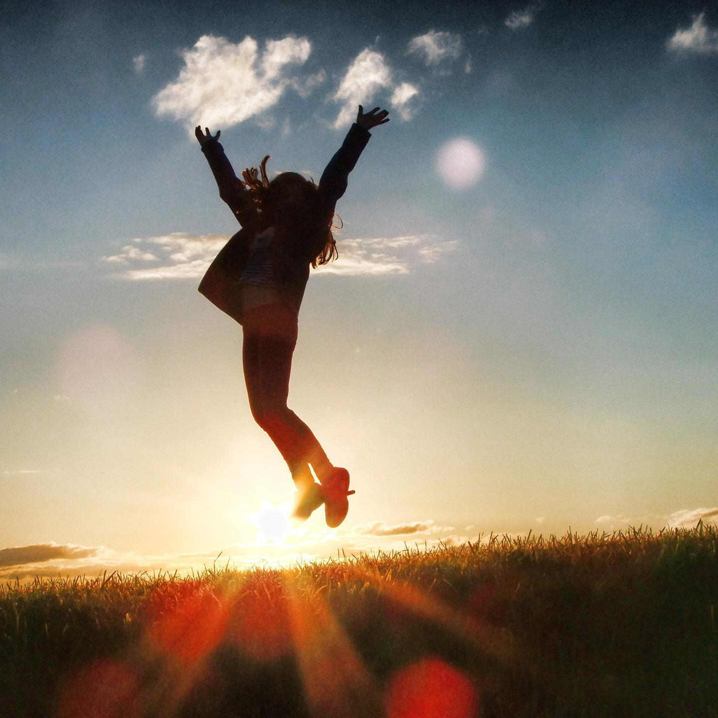 석양-잔디밭-하늘-두 팔-벌려-점프하는-여성