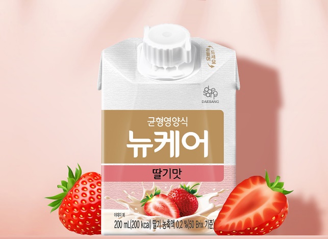 뉴케어-딸기맛-종이팩-한-개와-딸기-장식-두-개