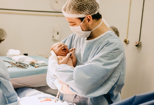 갓-태어난-신생아를-안고-있는-산부인과-의사