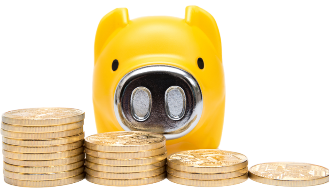 노란 돼지저금통 앞에 동전이 쌓여 있다.