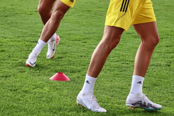 잔디 위에서 축구를 하는 축구선수 2명이 있고, 그들의 종아리 근육을 집중 확대한 것으로 매끄러운 근육이다. 유니폼은 노란색이다.