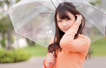 우산을 받치고 있는 젊은 여자의 모습